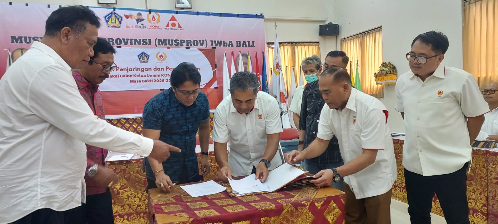 Ketua Tim Penjaringan dan Penyaringan KONI Bali, Maryoto Subekti tampak memeriksa berkas-berkas yang diserahkan Wagub Bali I Nyoman Giri Prasta sebagai bakal calon ketum KONI Bali. (Foto: hms)