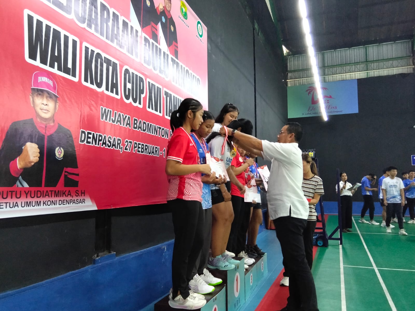 Ketua Umum PBSI Kota Denpasar Suteja Kumara mengalungkan medali kepada pebulutangkis juara Wali Kota Cup 2026 yang berakhir Minggu (1/3/2026) (Foto: suwandhi PBSI dps)