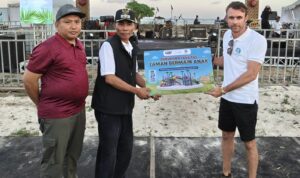 Pimpinan Saraya Resort, Adrian James Campbell, (kanan) menyerahkan Flayer pembangunan Arena hiburan anak Pengantap kepada Kepala Desa Induk Buwun Mas, Rochidi, S.IP., (dua dari kiri). (Foto perspectivesnews/Bil)