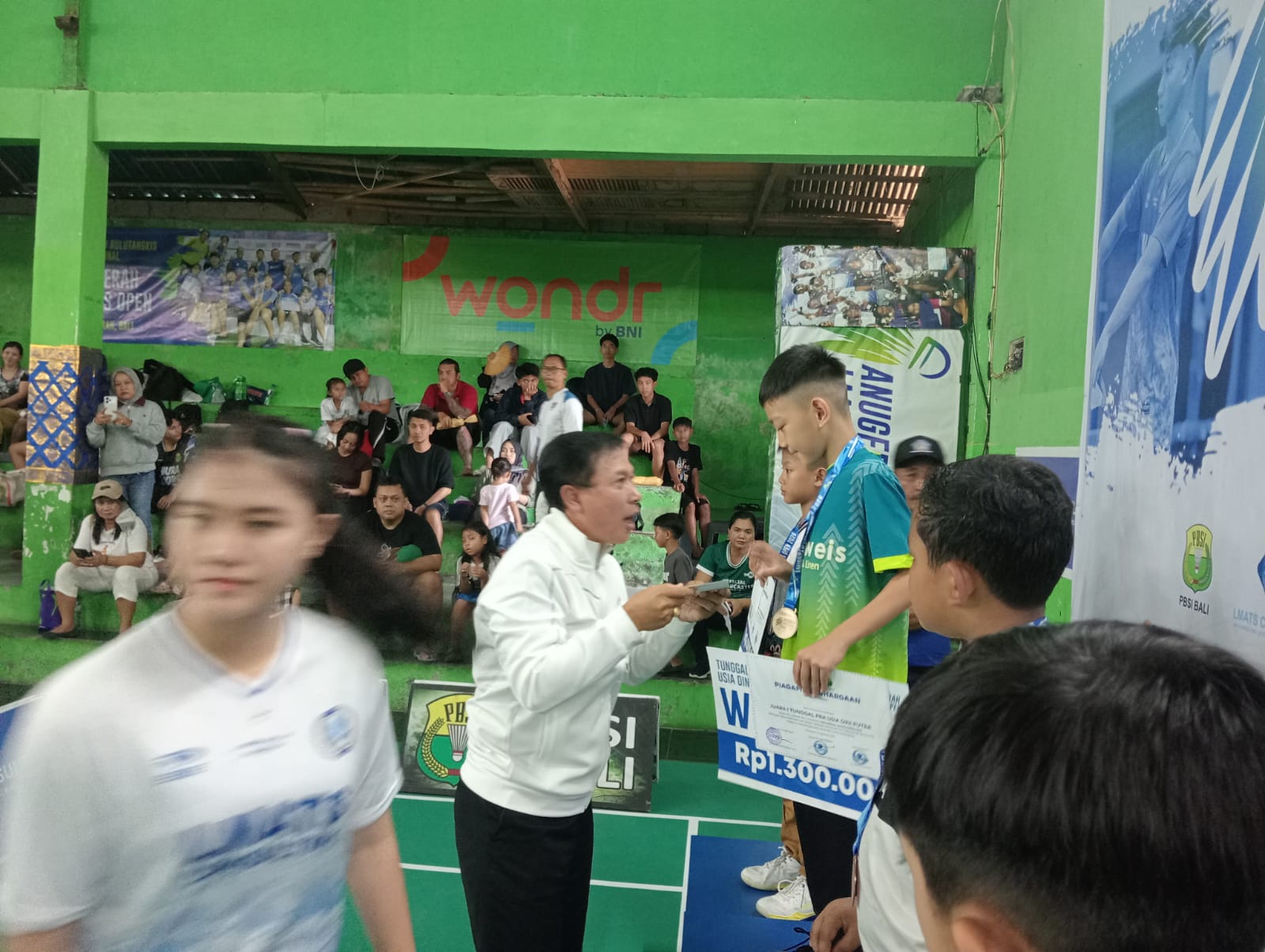 Ketua Umum Pengprov PBSI Bali I Wayan Winurjaya menyerahkan hadiah kepada pemenang Kejuaraan Bulu Tangkis Anugerah LMATS Open VII/2026 di GOR Anugerah Denpasar, Jumat (21/8/2026) (Foto: djo)
